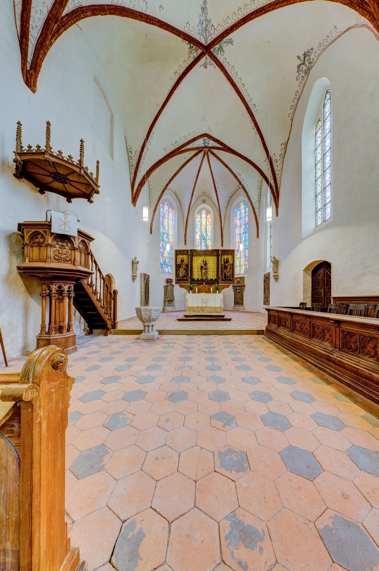 A bright vaulted church interior with stained glass