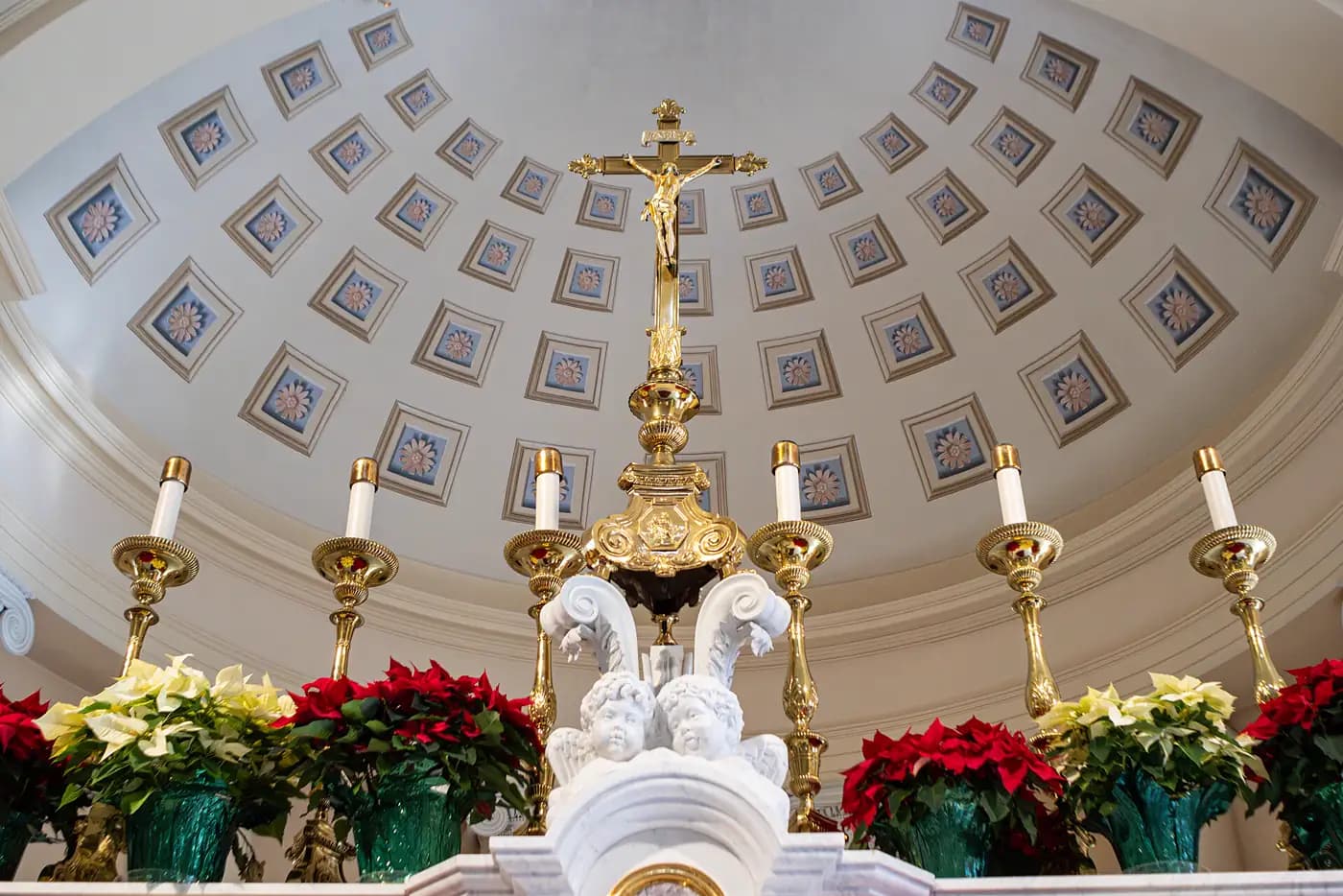 Catholic: a gilded crucifix and candlesticks on a marble high altar beneath a coffered dome