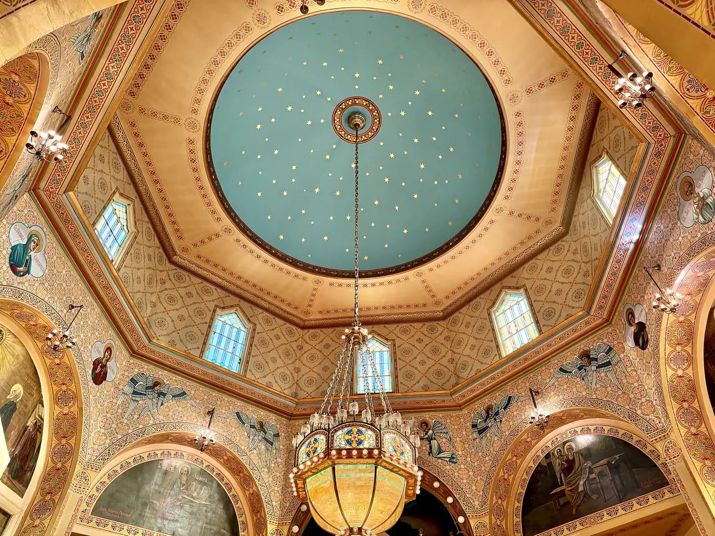Eastern Orthodox: a star-painted dome over patterned walls, icons of the saints and a hanging chandelier